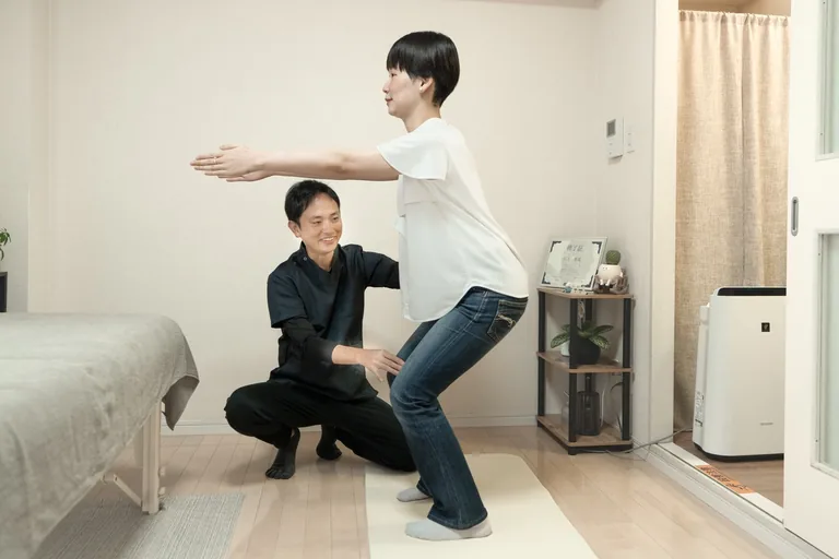立った姿勢で膝を曲げ、身体の使い方を確認している様子