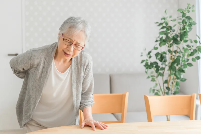 腰の痛みに悩む高齢女性